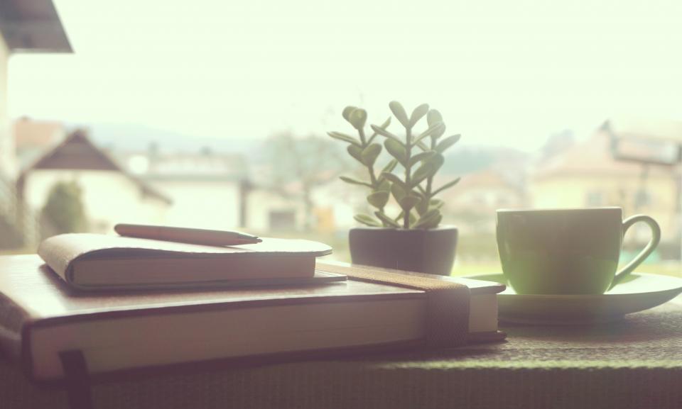 Notebooks, a pen and a cup of tea by a bright window — planning the week during a Sunday reset routine